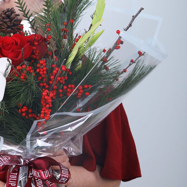 03 Christmas bouquet with orchid, red roses, winter pine, berries, and festive ribbon wrapping