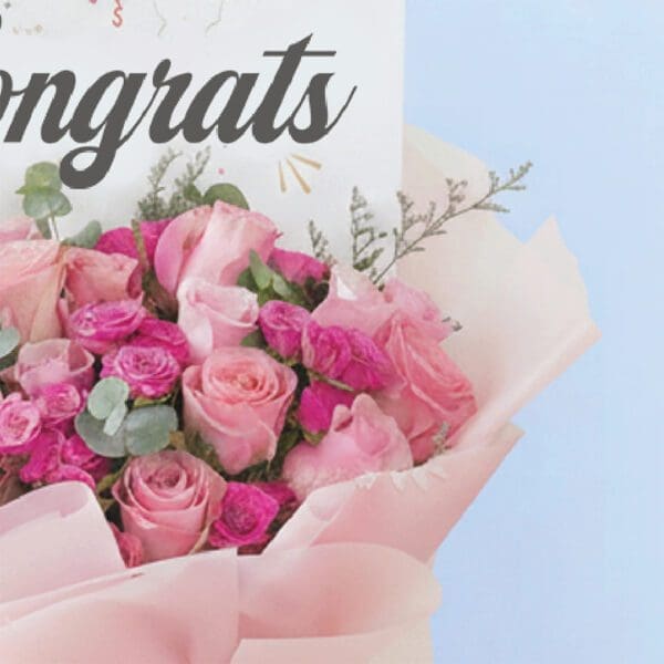 03 Bouquet featuring hand-tied pink roses, hot pink spray roses & eucalyptus in blush wrap, finished with a “Congrats” card.