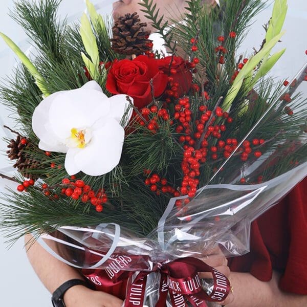 04 Christmas bouquet with orchid, red roses, winter pine, berries, and festive ribbon wrapping