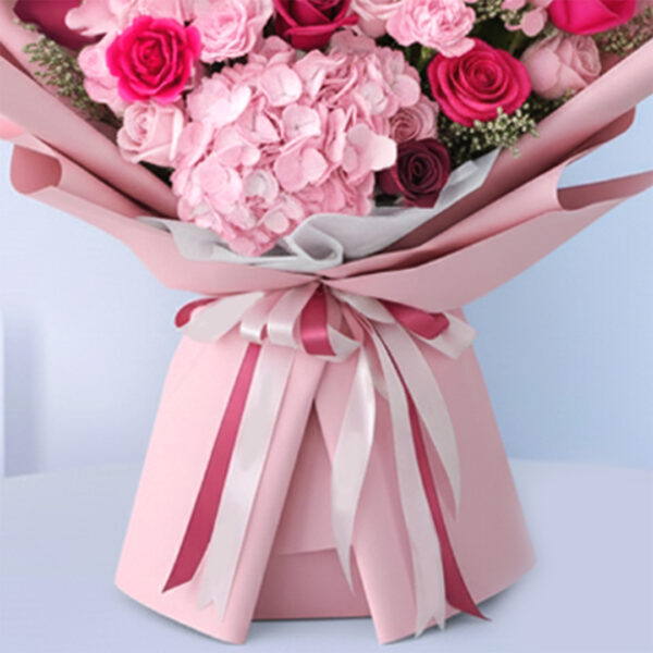 Pink baby girl bouquet with roses, hydrangeas, carnations, and “It’s a Girl” card.