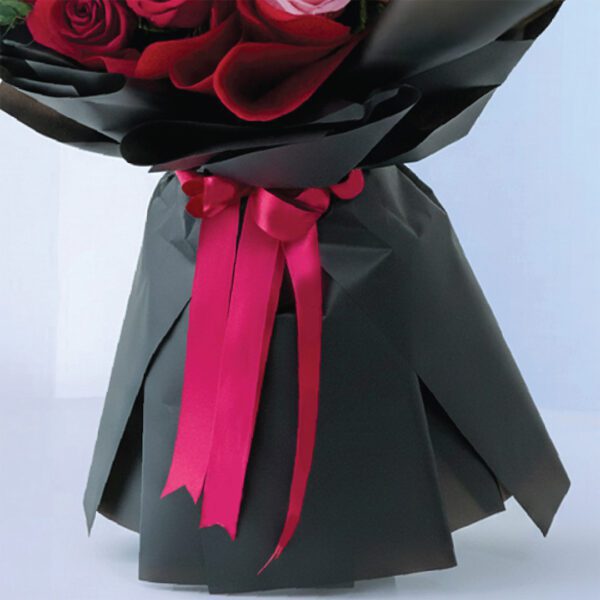 05 Birthday bouquet with pink and red roses wrapped in black paper and bright ribbon.