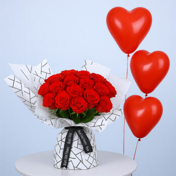 Bouquet of 16 red roses in patterned white wrap, paired with red heart-shaped balloons.