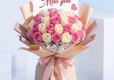 Bouquet featuring hand-tied pink roses & white roses in pastel wrap, finished with a “Miss You” card.