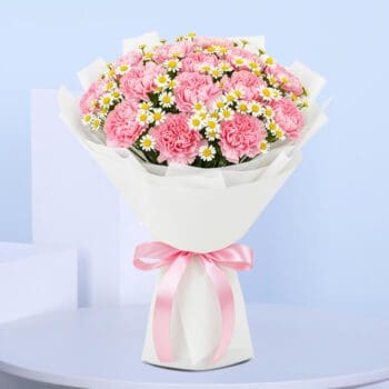 Bouquet of hand-tied light pink carnations & tanacetum in white wrap, finished with a pink satin ribbon.