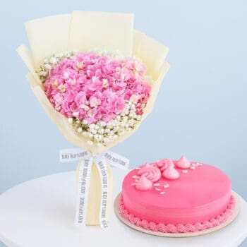 Pink hydrangeas with fillers in elegant wrap, paired with a 1 kg strawberry-flavoured cake.