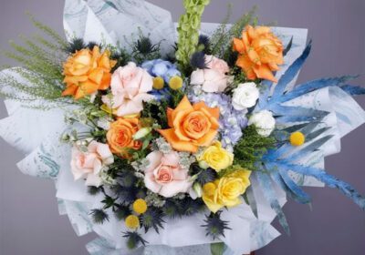 Bouquet featuring hand-tied roses, hydrangeas & exotic flowers in designer wrap, finished with lush greenery.