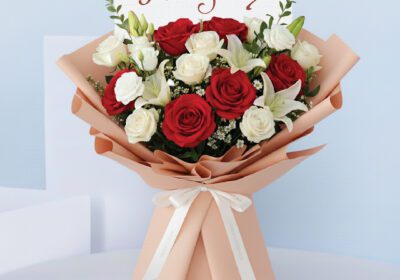 Bouquet featuring hand-tied red roses, white roses & lilies in peach wrap, finished with an “I am Sorry” card.