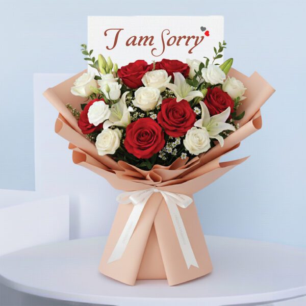 Bouquet featuring hand-tied red roses, white roses & lilies in peach wrap, finished with an “I am Sorry” card.