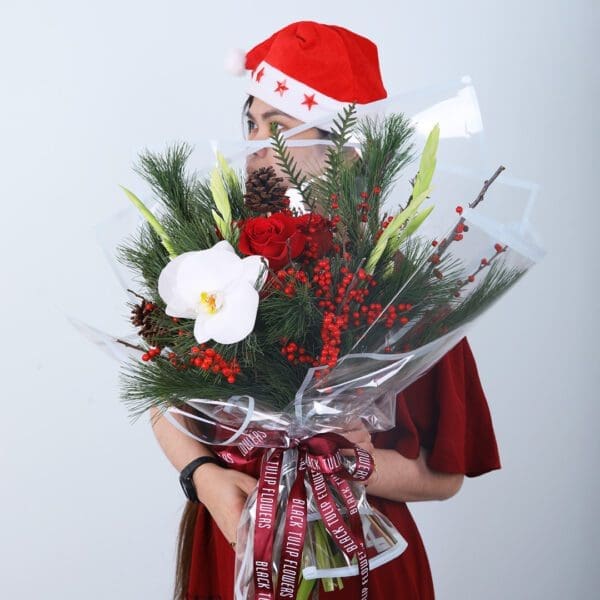 winter-orchid-bouquet Christmas bouquet with orchid, red roses, winter pine, berries, and festive ribbon wrappin