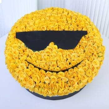 Yellow spray roses arranged in a cool sunglasses smiley-face floral box design.