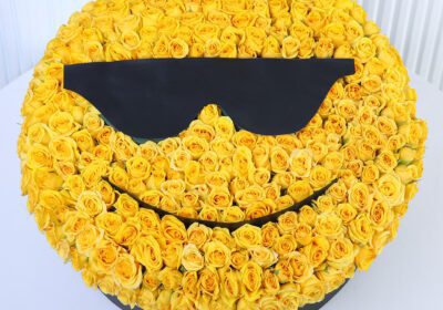 Yellow spray roses arranged in a cool sunglasses smiley-face floral box design.