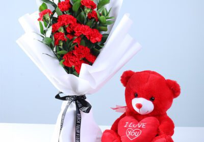 20 red carnations and ruscus greens in premium white wrapping, finished with an “I Love You” teddy.