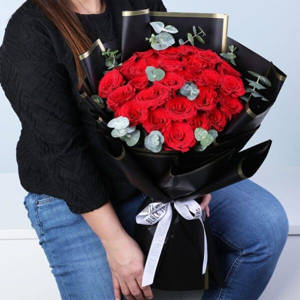 20-red-roses-bouquet-eucalyptus-black-wrap. 20 red roses bouquet with eucalyptus in a black wrap