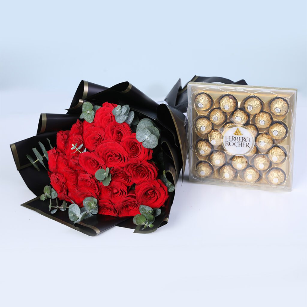 A gift combo of 20 red roses and 10 eucalyptus stems in black wrap, finished with a ribbon, and Ferrero Rocher chocolate gift box.