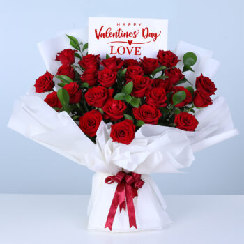 25 red roses bouquet wrapped in white paper with ribbon.