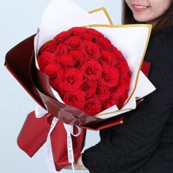 Bouquet of 30 red roses in white and maroon wrapping style with gold edging, finished with a ribbon.