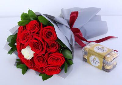 Red rose bouquet with green foliage and luxury wrapping, paired with ferrero chocolates