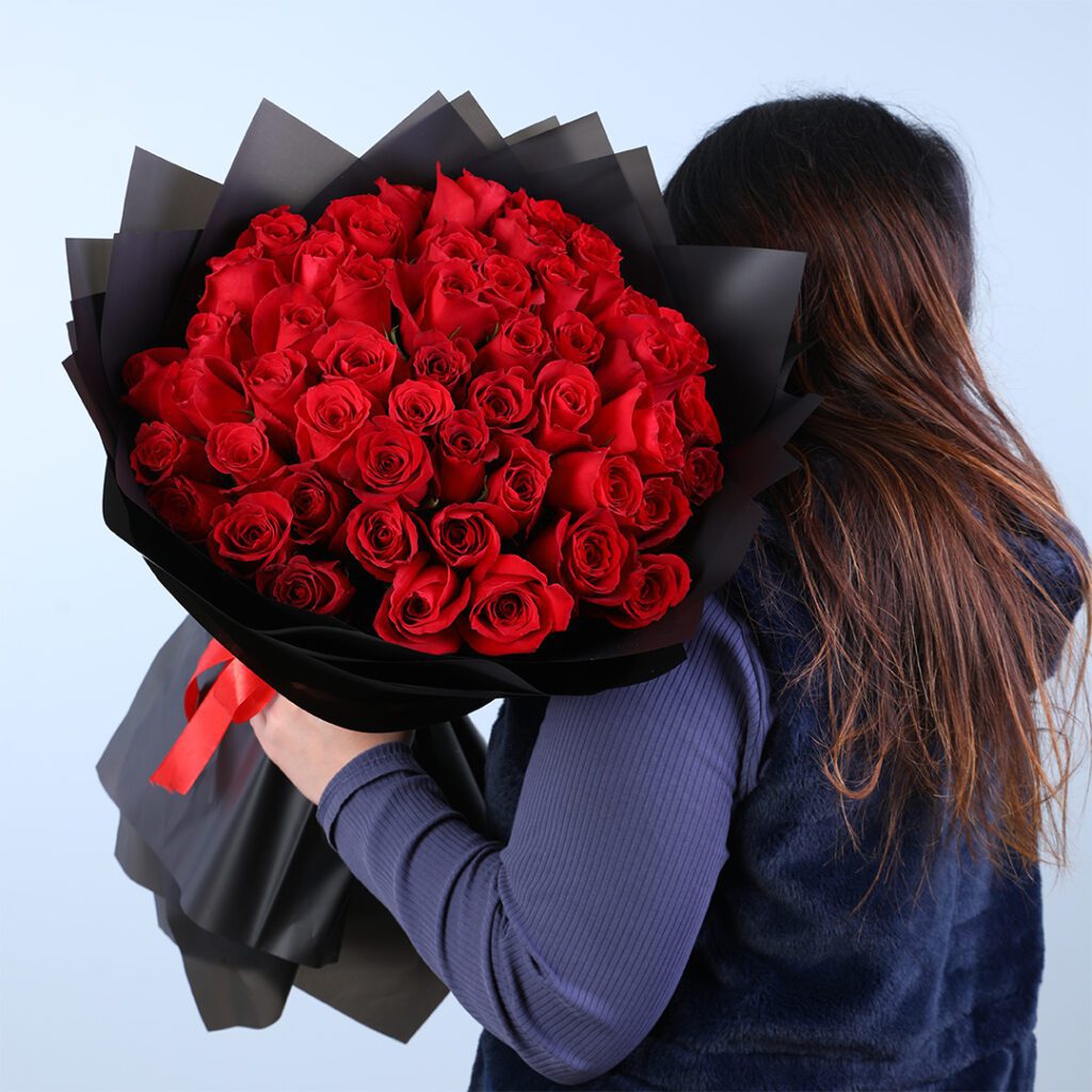 50 red rose bouquet in black wrap, finished with a red ribbon.
