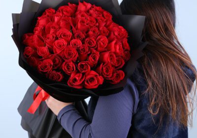 50 red rose bouquet in black wrap, finished with a red ribbon.