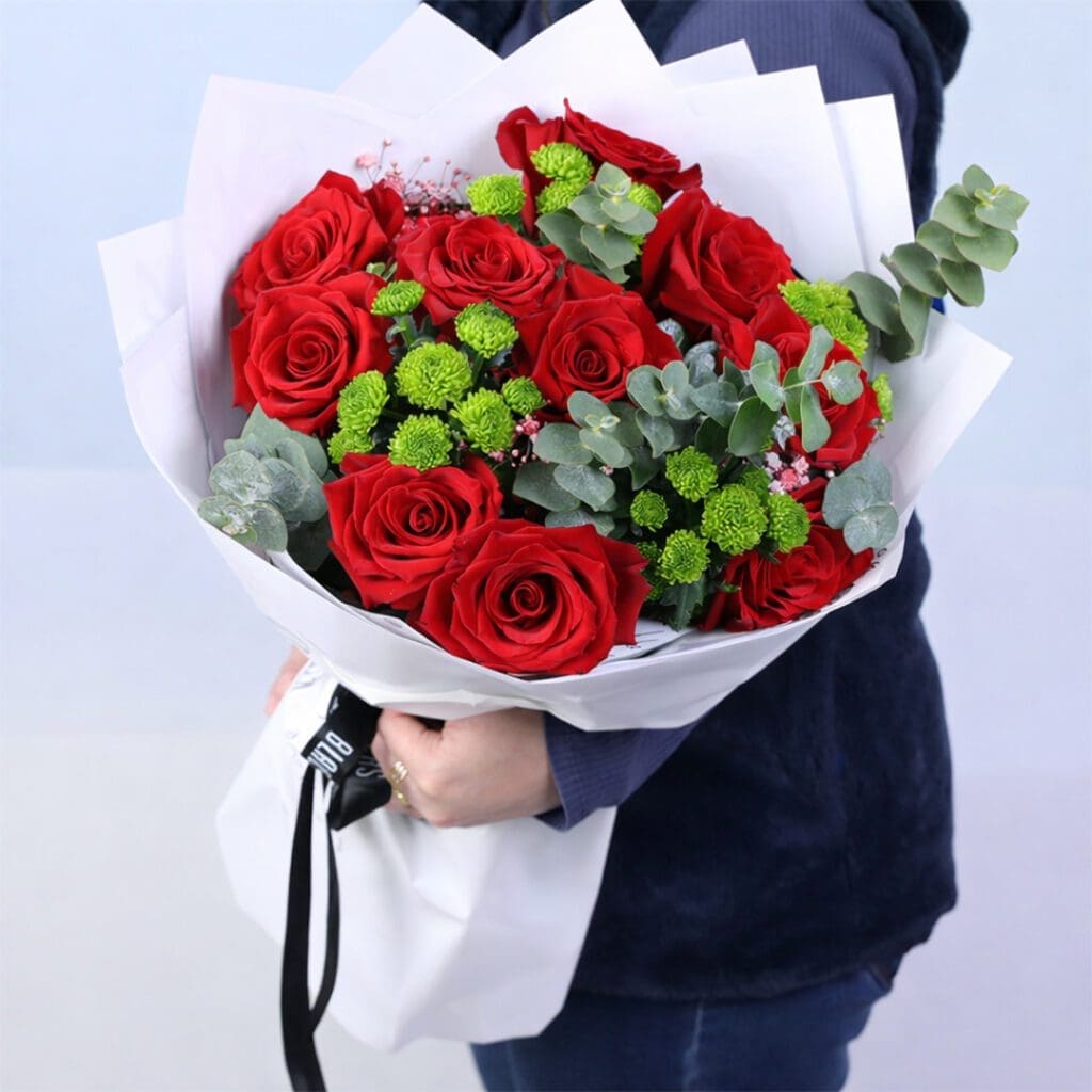 Red roses with green chrysanthemums and eucalyptus leaves in elegant white wrap