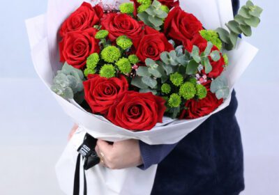 Red roses with green chrysanthemums and eucalyptus leaves in elegant white wrap