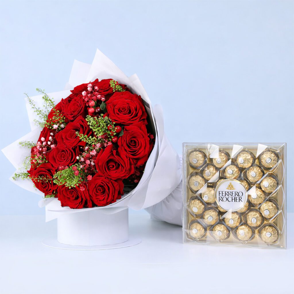 Red roses with delicate fillers in a white wrap, with a Ferrero Rocher box.