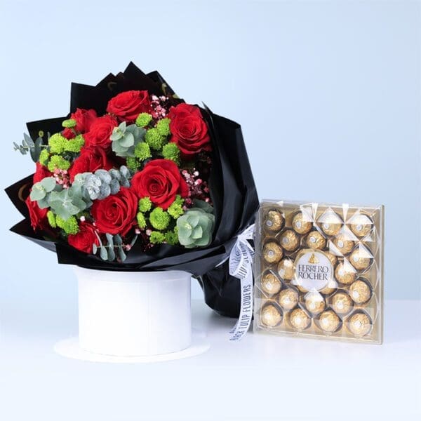 red-roses-ferrero-romance-combo Red roses with eucalyptus leaves and green filler flowers in elegant black wrapping, with a Ferrero Rocher chocolate box