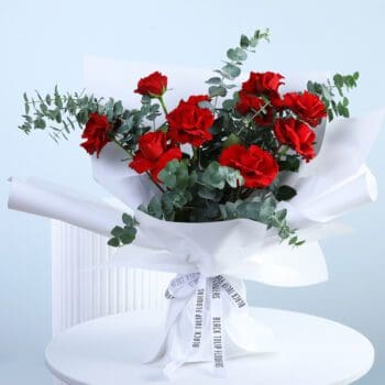 A bouquet of red roses in white wrap