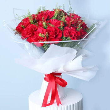 Red roses in white wrap with a ribbon.