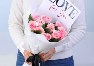 10 light pink roses with ruscus in a white wrap with note 'Love For You'