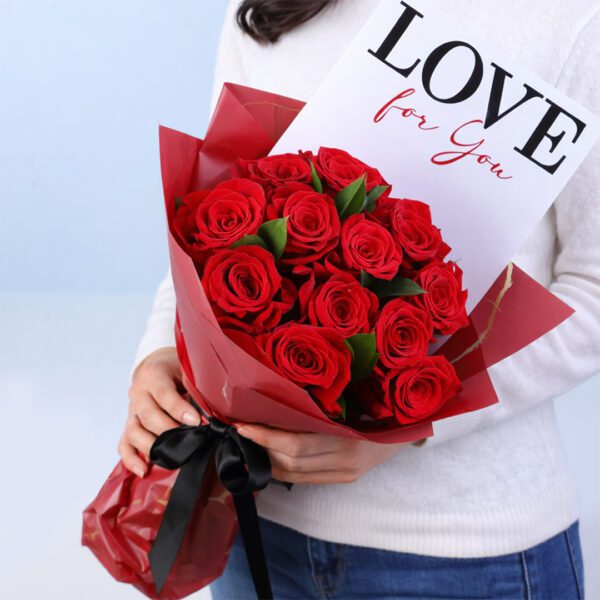 10 red roses with ruscus in a white wrap with note 'Love for You'