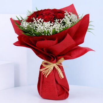 Bouquet featuring 10 red roses, white baby’s breath and green foliage in premium red wrapping