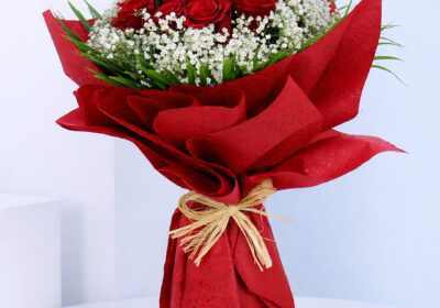 Bouquet featuring 10 red roses, white baby’s breath and green foliage in premium red wrapping
