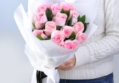 12 light pink roses with rusucs in an off white luxury wrap