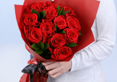 12 red roses with ruscus in a red luxury wrap