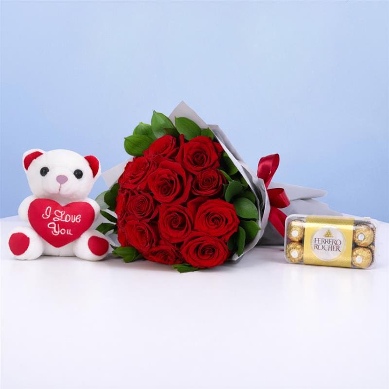 15 red roses with green foliage in premium wrap with a teddy bear and ferraro gift combo
