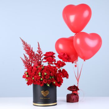 Fresh red roses with fillers in a box with red love balloons