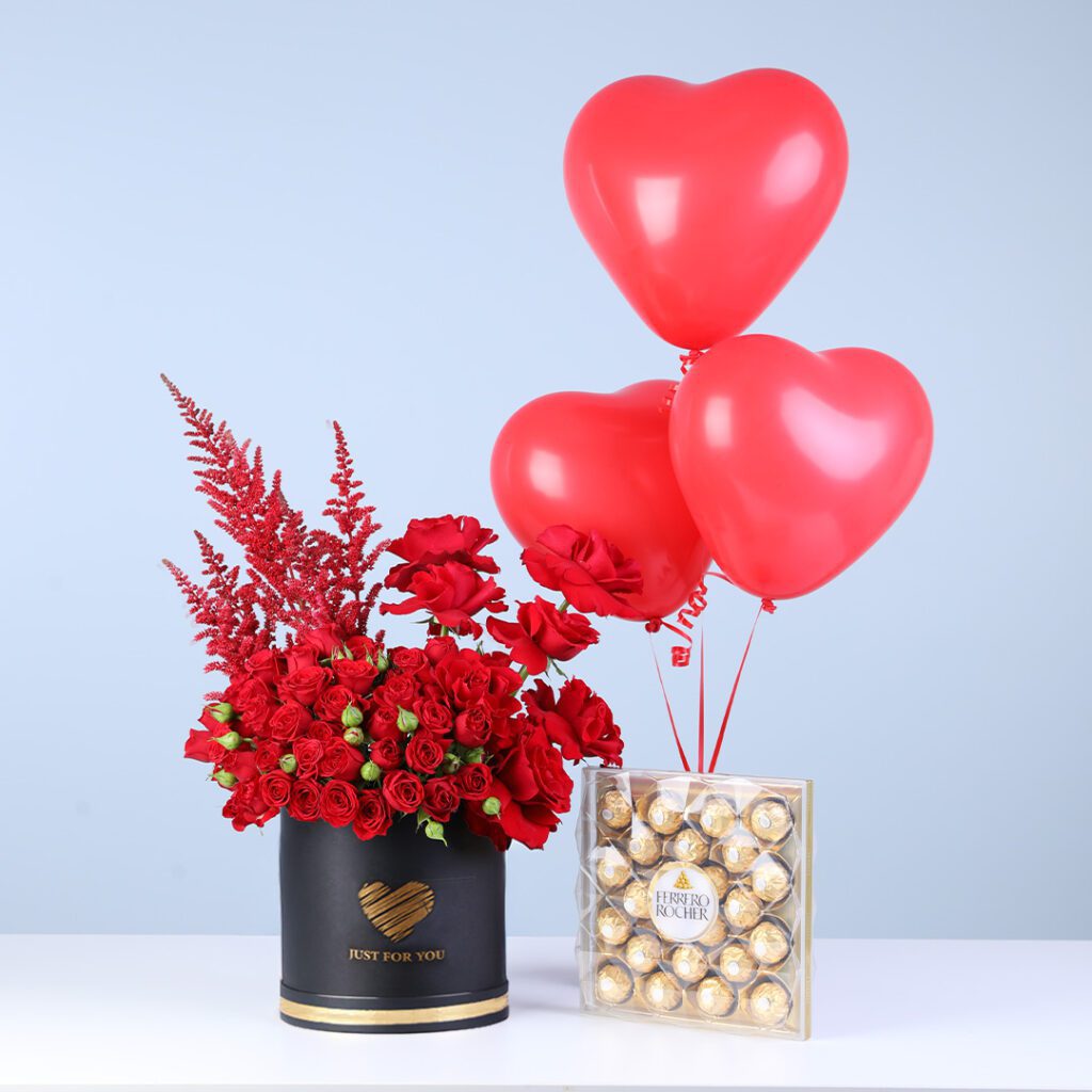 Red spray roses in a premium round box style, finished with a Ferrero Rocher chocolate box and 3 love balloons