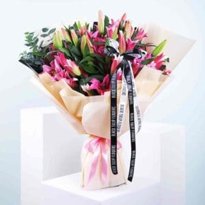 An arrangement of pink and white flowers, artistically tied with a ribbon, showcasing a fresh and elegant look.