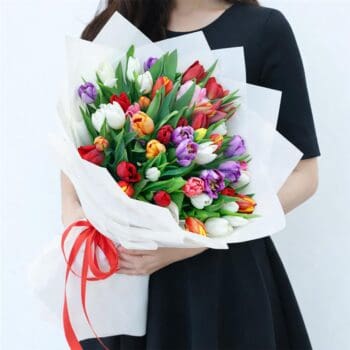 Hand bouquet of 50 colourful mixed tulips in assorted soft and vibrant colors wrapped neatly for gifting.