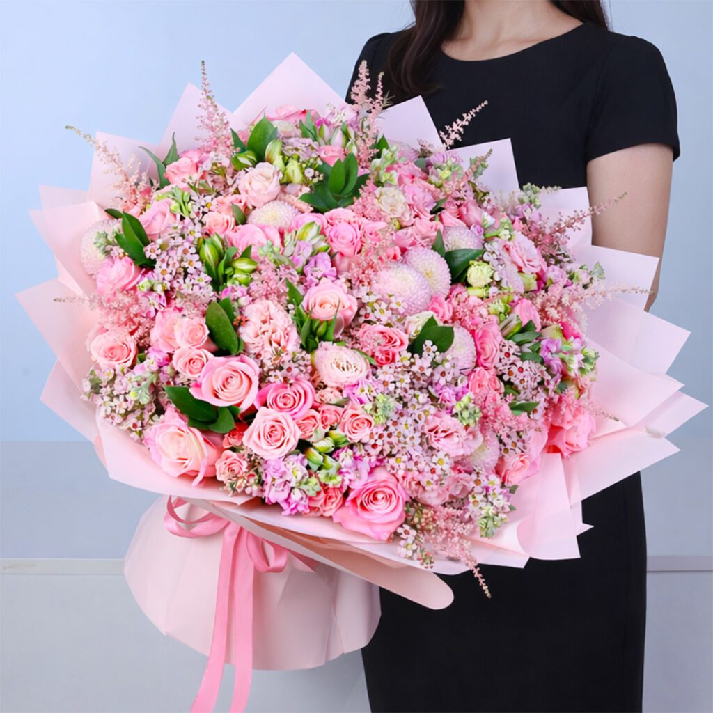 Full pink floral arrangement with multiple flower varieties creating a balanced and premium bouquet.