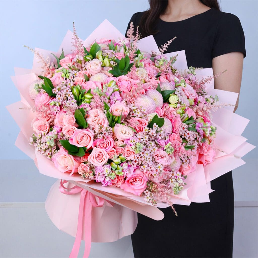 Full pink floral arrangement with multiple flower varieties creating a balanced and premium bouquet.