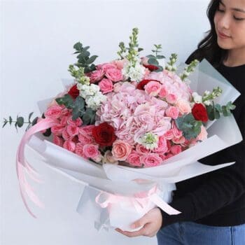 Classic Sweet Harmony Flowers featuring hydrangeas, roses, and eucalyptus arranged in a pastel floral design for gifting