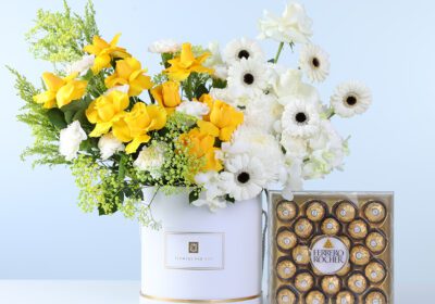Golden White Bloom Arrangement Ferrero 24 Pcs featuring yellow roses, white roses, carnations, gerberas, orchids, and chocolates arranged in a floral box