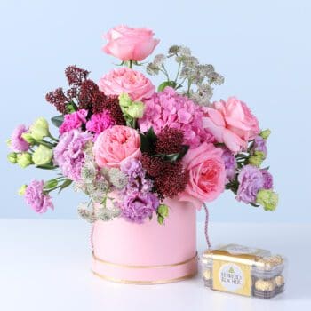 Mixed Pastel Flower Box with Ferrero featuring pink roses, hydrangea, lisianthus, carnations, and chocolates arranged in a pink hatbox for gifting