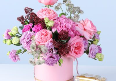 Mixed Pastel Flower Box with Ferrero featuring pink roses, hydrangea, lisianthus, carnations, and chocolates arranged in a pink hatbox for gifting