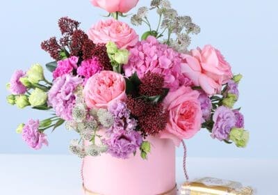 Mixed Pastel Flower Box with Ferrero featuring pink roses, hydrangea, lisianthus, carnations, and chocolates arranged in a pink hatbox for gifting