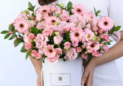 Elegant pink roses and gerberas floral arrangement in a white gift box with fresh greenery
