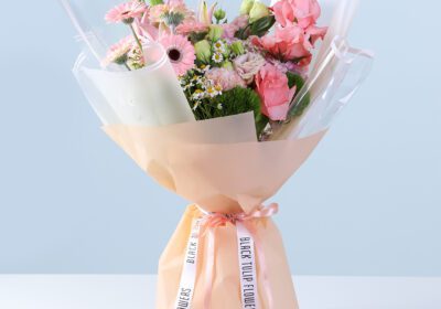 Soft Pink Bliss Bouquet with pink gerberas, roses, lilies, hydrangea, and seasonal flowers wrapped in peach for gifting