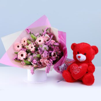 Soft Pink Celebration Teddy Combo featuring gerberas, lilies, baby roses, statice pink, chrysanthemums, and a teddy arranged in pink wrapping for gifting